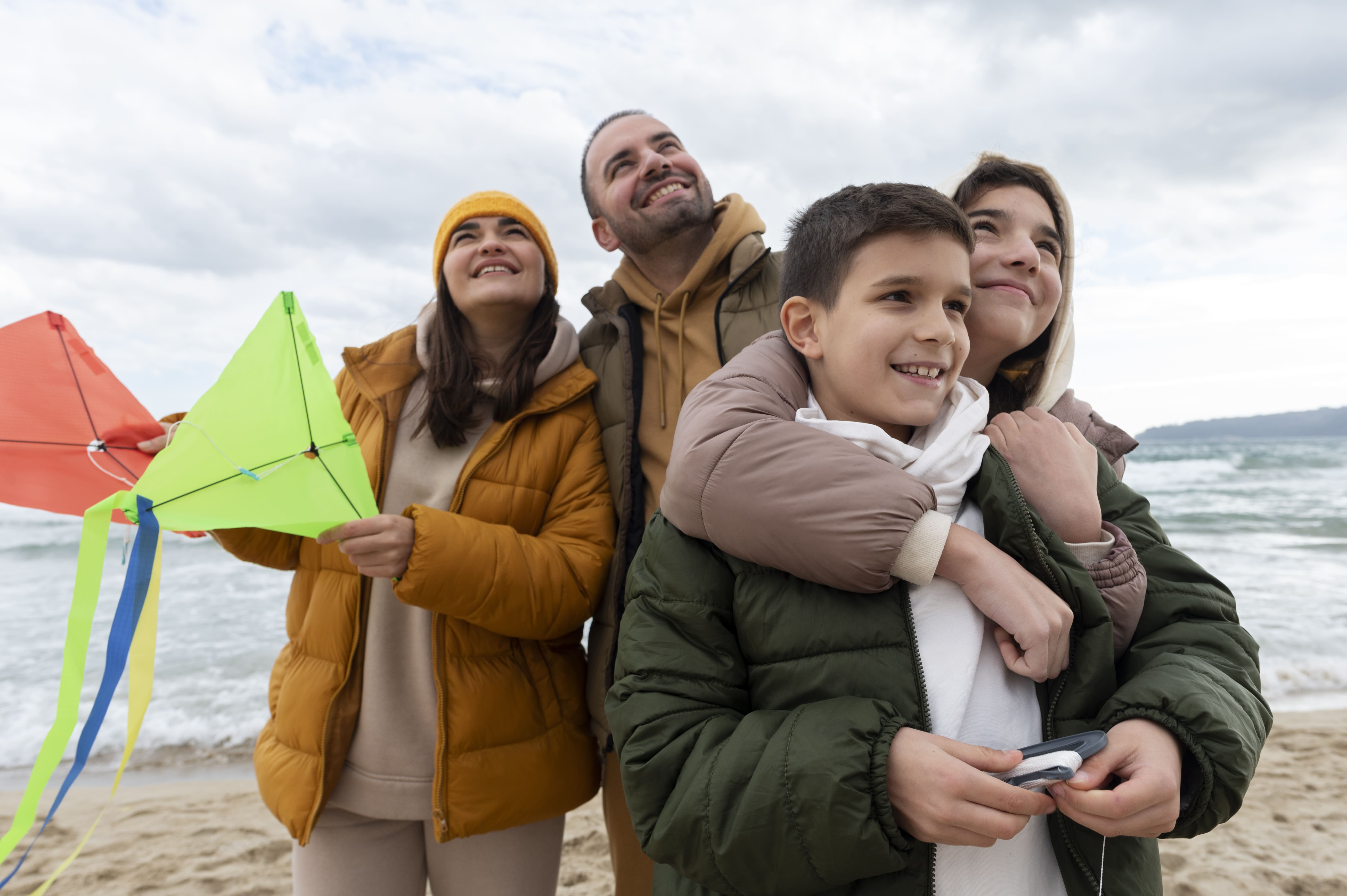 familia volando una cometa en la playa